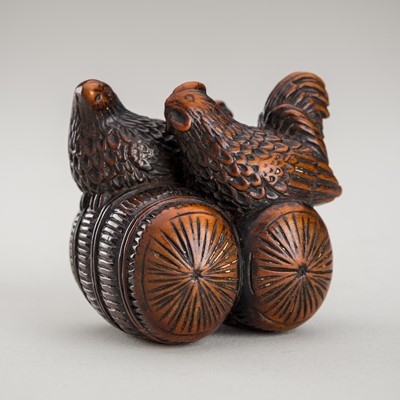 Lot 456 - A WOOD NETSUKE OF A ROOSTER AND HEN ON A RICE BALE