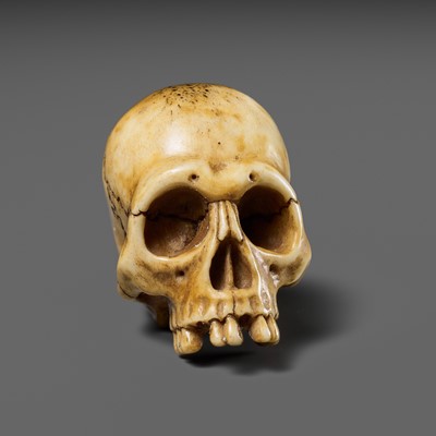 Lot 256 - SEKIMUNE: A FINE ANTLER NETSUKE OF A HUMAN SKULL