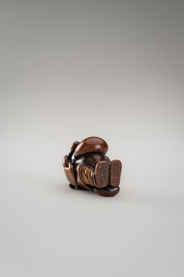 Lot 460 - AN AMUSING WOOD NETSUKE OF A DISGUISED TANUKI