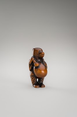 Lot 460 - AN AMUSING WOOD NETSUKE OF A DISGUISED TANUKI