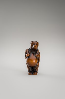 Lot 460 - AN AMUSING WOOD NETSUKE OF A DISGUISED TANUKI