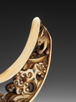 Lot 256 - A VERY RARE BOAR TUSK NETSUKE WITH LUNAR HARES INSIDE THE CRESCENT MOON