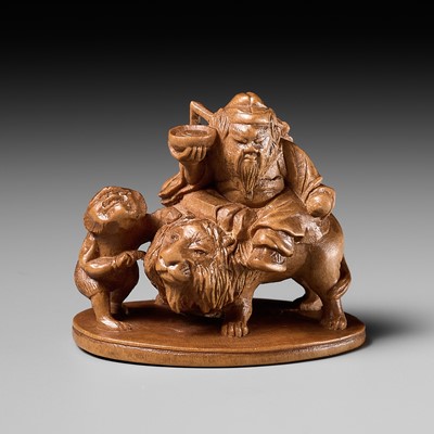 Lot 285 - TOMIN: A WOOD NETSUKE OF SHOKI RIDING A LION WITH ONI