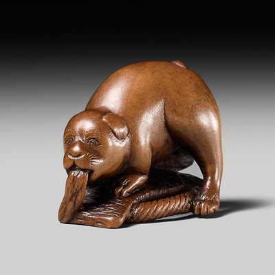 Lot 475 - RYUKEI: A WOOD NETSUKE OF A PUPPY PLAYING WITH A SANDAL