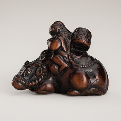 Lot 1333 - A WOOD NETSUKE OF AN OX-HERDER AND OX, INSCRIBED TOMOTADA