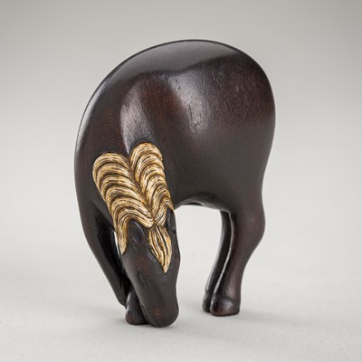 Lot 1366 - AN INLAID WOOD NETSUKE OF A GRAZING HORSE