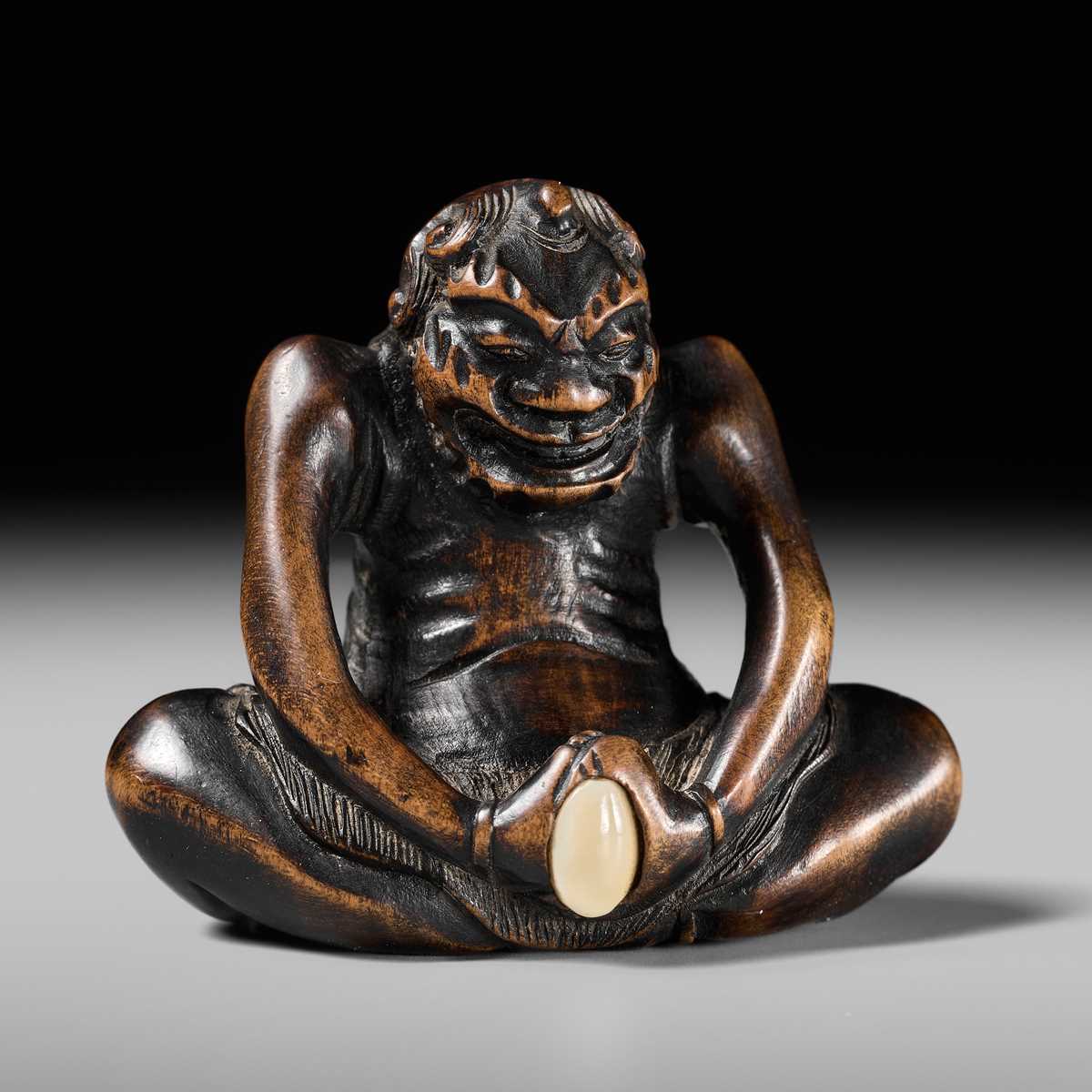 Lot 425 - A RARE WOOD NETSUKE OF AN ONI PARODYING AN EGG TESTER