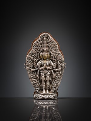 Lot 1 - A PARCEL-GILT SILVER REPOUSSÉ GAU DEPICTING EKADASHAMUKHA AVALOKITESHVARA, TIBET, 17TH-18TH CENTURY