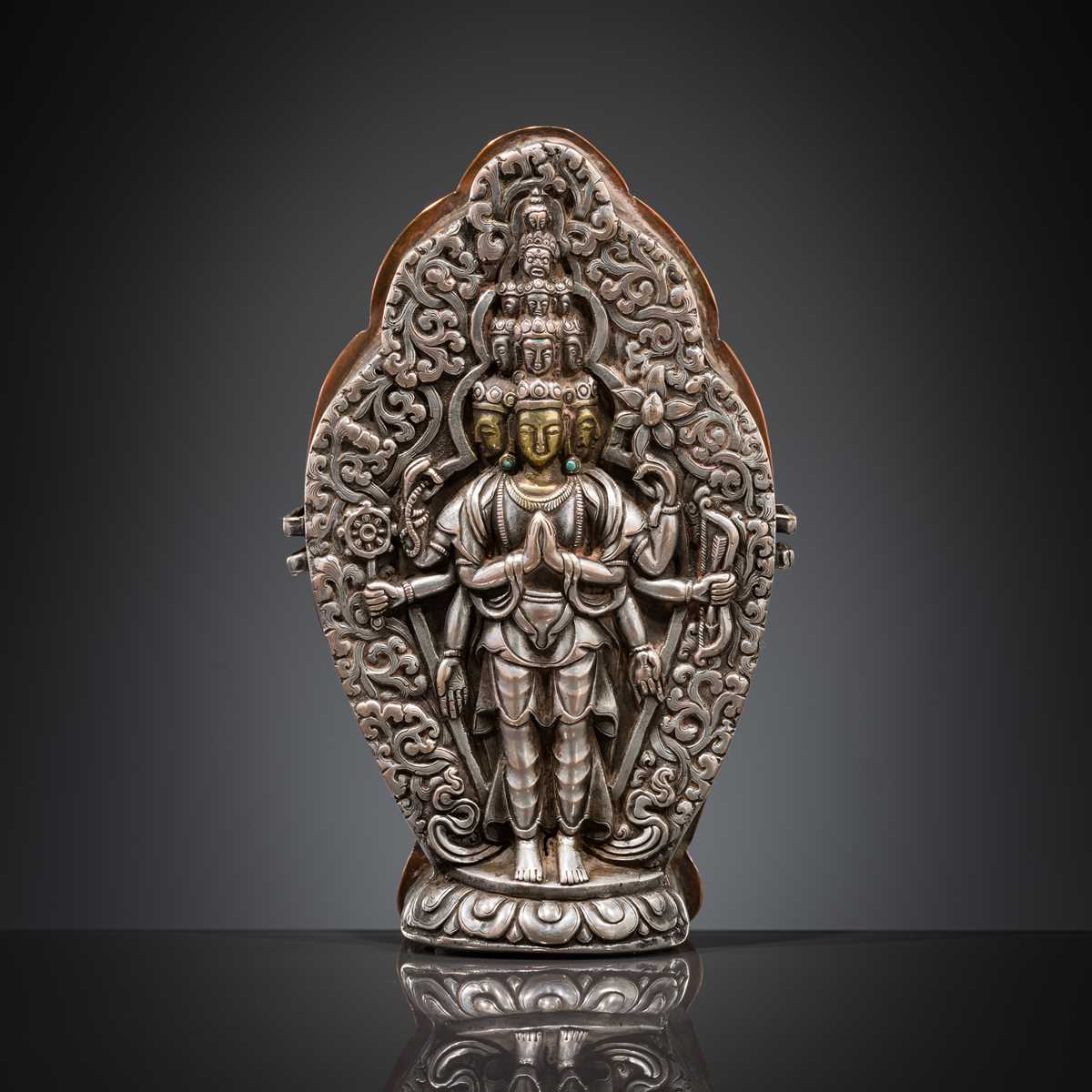 Lot 1 - A PARCEL-GILT SILVER REPOUSSÉ GAU DEPICTING EKADASHAMUKHA AVALOKITESHVARA, TIBET, 17TH-18TH CENTURY