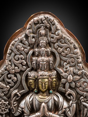 Lot 1 - A PARCEL-GILT SILVER REPOUSSÉ GAU DEPICTING EKADASHAMUKHA AVALOKITESHVARA, TIBET, 17TH-18TH CENTURY