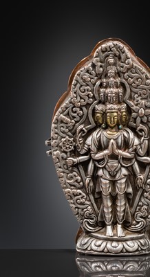 Lot 1 - A PARCEL-GILT SILVER REPOUSSÉ GAU DEPICTING EKADASHAMUKHA AVALOKITESHVARA, TIBET, 17TH-18TH CENTURY