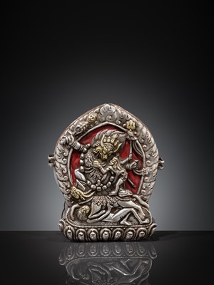 Lot 306 - A PARCEL-GILT SILVER REPOUSSÉ GAU DEPICTING VAJRABHAIRAVA, BHUTAN, 18TH-19TH CENTURY