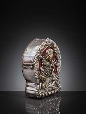 Lot 306 - A PARCEL-GILT SILVER REPOUSSÉ GAU DEPICTING VAJRABHAIRAVA, BHUTAN, 18TH-19TH CENTURY