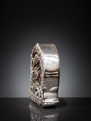 Lot 306 - A PARCEL-GILT SILVER REPOUSSÉ GAU DEPICTING VAJRABHAIRAVA, BHUTAN, 18TH-19TH CENTURY