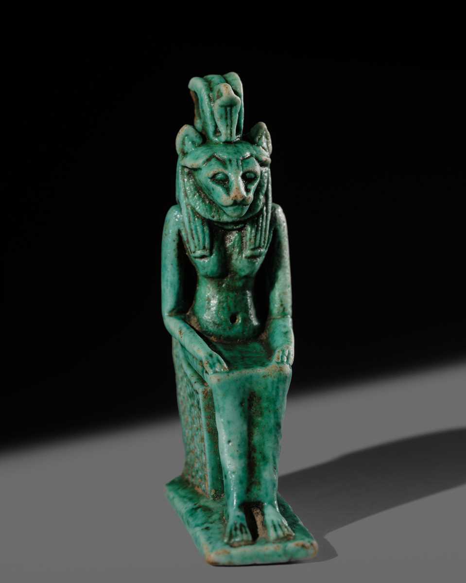 A TURQUOISE-GLAZED FAIENCE AMULET OF THE ENTHRONED SEKHMET, LATE PERIOD, DYNASTY XXVI (SAITE)