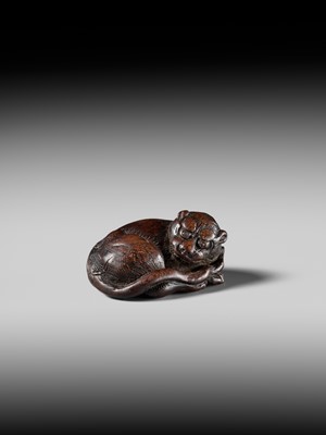 A SUPERB WOOD NETSUKE OF A RECUMBENT TIGER, ATTRIBUTED TO TAMETAKA