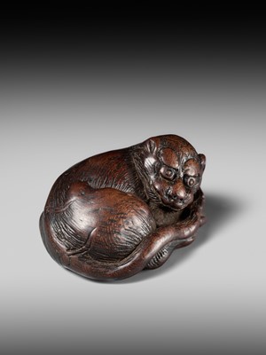 A SUPERB WOOD NETSUKE OF A RECUMBENT TIGER, ATTRIBUTED TO TAMETAKA