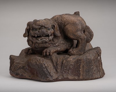 Lot 1943 - A GLAZED CERAMIC OKIMONO OF A SHISHI ON A ROCK