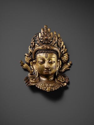 Lot 312 - A GILT-COPPER REPOUSSÉ LINGA COVER WITH THE FACE OF SHIVA, MALLA PERIOD, NEPAL, 15TH-16TH CENTURY