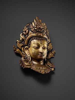 Lot 312 - A GILT-COPPER REPOUSSÉ LINGA COVER WITH THE FACE OF SHIVA, MALLA PERIOD, NEPAL, 15TH-16TH CENTURY