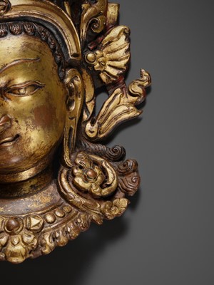 Lot 312 - A GILT-COPPER REPOUSSÉ LINGA COVER WITH THE FACE OF SHIVA, MALLA PERIOD, NEPAL, 15TH-16TH CENTURY