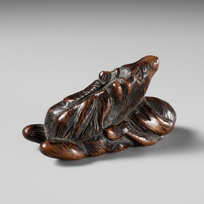 Lot 438 - AN EARLY WOOD NETSUKE OF A RECUMBENT HORSE