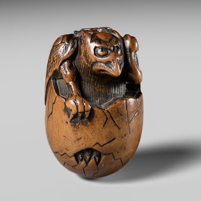 Lot 440 - A GOOD WOOD NETSUKE OF A HATCHING TENGU (TENGU NO TOMAGO)