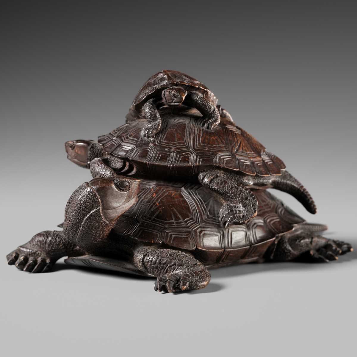 A FINE WOOD OKIMONO OF THREE TURTLES IN A PYRAMID