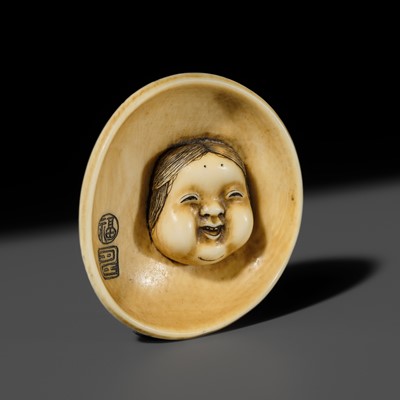 Lot 143 - MITSUHIRO: AN IVORY NETSUKE OF AN OKAME MASK INSIDE AN EARTHENWARE BOWL, DATED 1840