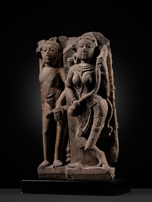 Lot 329 - A PINK SANDSTONE ARCHITECTURAL FRAGMENT DEPICTING AN APSARA AND A MALE ATTENDANT, CHANDELLA PERIOD, 11TH CENTURY