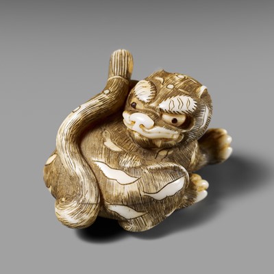 Lot 97 - AN OSAKA SCHOOL IVORY NETSUKE OF A RECUMBENT TIGER