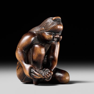 Lot 130 - MASANAO: A RARE WOOD NETSUKE OF OKAME CLIPPING HER TOENAILS