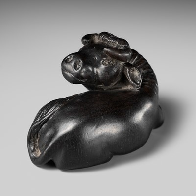 Lot 137 - AN EBONY WOOD NETSUKE OF A RECUMBENT OX, ATTRIBUTED TO MINKO