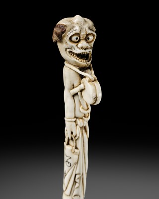 Lot 312 - AN AMUSING ANTLER CANE HANDLE OR SASHI NETSUKE OF A DRUNKEN REPENTANT ONI