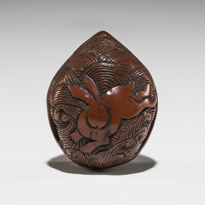 Lot 521 - A FINE KURUMI (WALNUT) NETSUKE DEPICTING A HARE PRANCING OVER WAVES