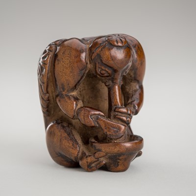 Lot 1388 - A SHUNGA WOOD NETSUKE OF A KONOHA TENGU GRINDING MISO