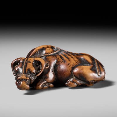 Lot 85 - TOMOTADA: A POWERFUL WOOD NETSUKE OF A RECUMBENT OX