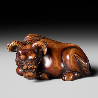 Lot 437 - A LARGE AND POWERFUL WOOD NETSUKE OF A RECUMBENT OX