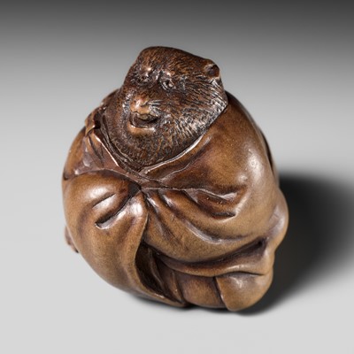 Lot 243 - A FINE AND HUMOROUS WOOD NETSUKE OF TANUKI DISGUISED AS A PRIEST