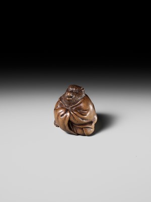 Lot 243 - A FINE AND HUMOROUS WOOD NETSUKE OF TANUKI DISGUISED AS A PRIEST