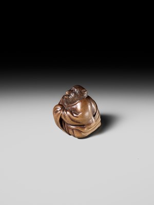 Lot 243 - A FINE AND HUMOROUS WOOD NETSUKE OF TANUKI DISGUISED AS A PRIEST