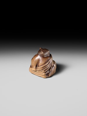 Lot 243 - A FINE AND HUMOROUS WOOD NETSUKE OF TANUKI DISGUISED AS A PRIEST