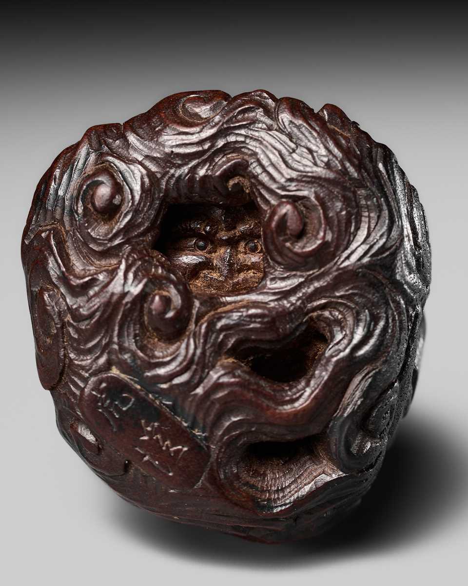 Lot 154 - KOKEI: A FINE WOOD NETSUKE OF RAIJIN PEERING THROUGH CLOUDS