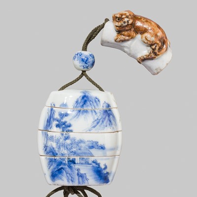 Lot 424 - A SMALL BLUE AND WHITE PORCELAIN THREE-CASE INRO WITH EN SUITE OJIME AND ‘TIGER ON BAMBOO’ NETSUKE