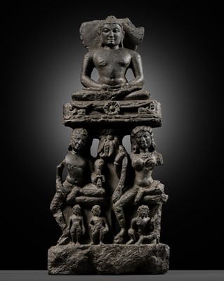 Lot 334 - A BLACK STONE STELE DEPICTING AN ENTHRONED MAHAVIRA ATTENDED BY A YAKSHA AND YAKSHI, PALA PERIOD, 11TH-12TH CENTURY