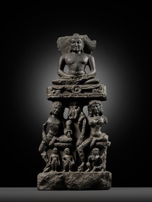 Lot 334 - A BLACK STONE STELE DEPICTING AN ENTHRONED MAHAVIRA ATTENDED BY A YAKSHA AND YAKSHI, PALA PERIOD, 11TH-12TH CENTURY