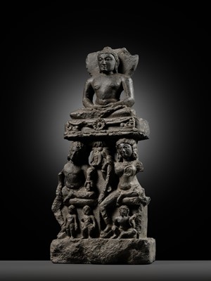 Lot 334 - A BLACK STONE STELE DEPICTING AN ENTHRONED MAHAVIRA ATTENDED BY A YAKSHA AND YAKSHI, PALA PERIOD, 11TH-12TH CENTURY