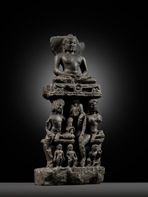 Lot 334 - A BLACK STONE STELE DEPICTING AN ENTHRONED MAHAVIRA ATTENDED BY A YAKSHA AND YAKSHI, PALA PERIOD, 11TH-12TH CENTURY