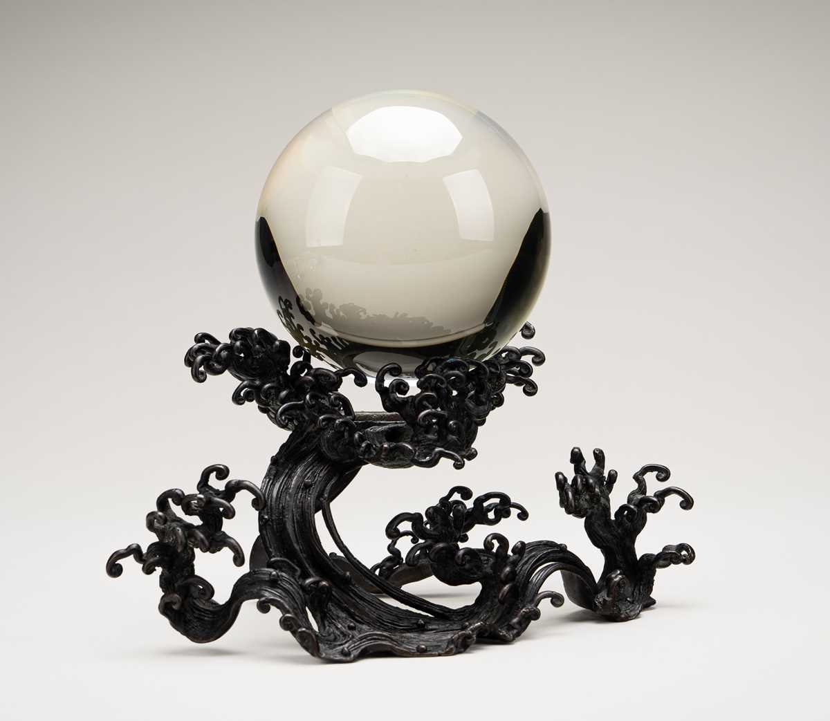 AN OKIMONO OF A ROCK CRYSTAL SPHERE ON A FINE BRONZE WAVE-FORM STAND