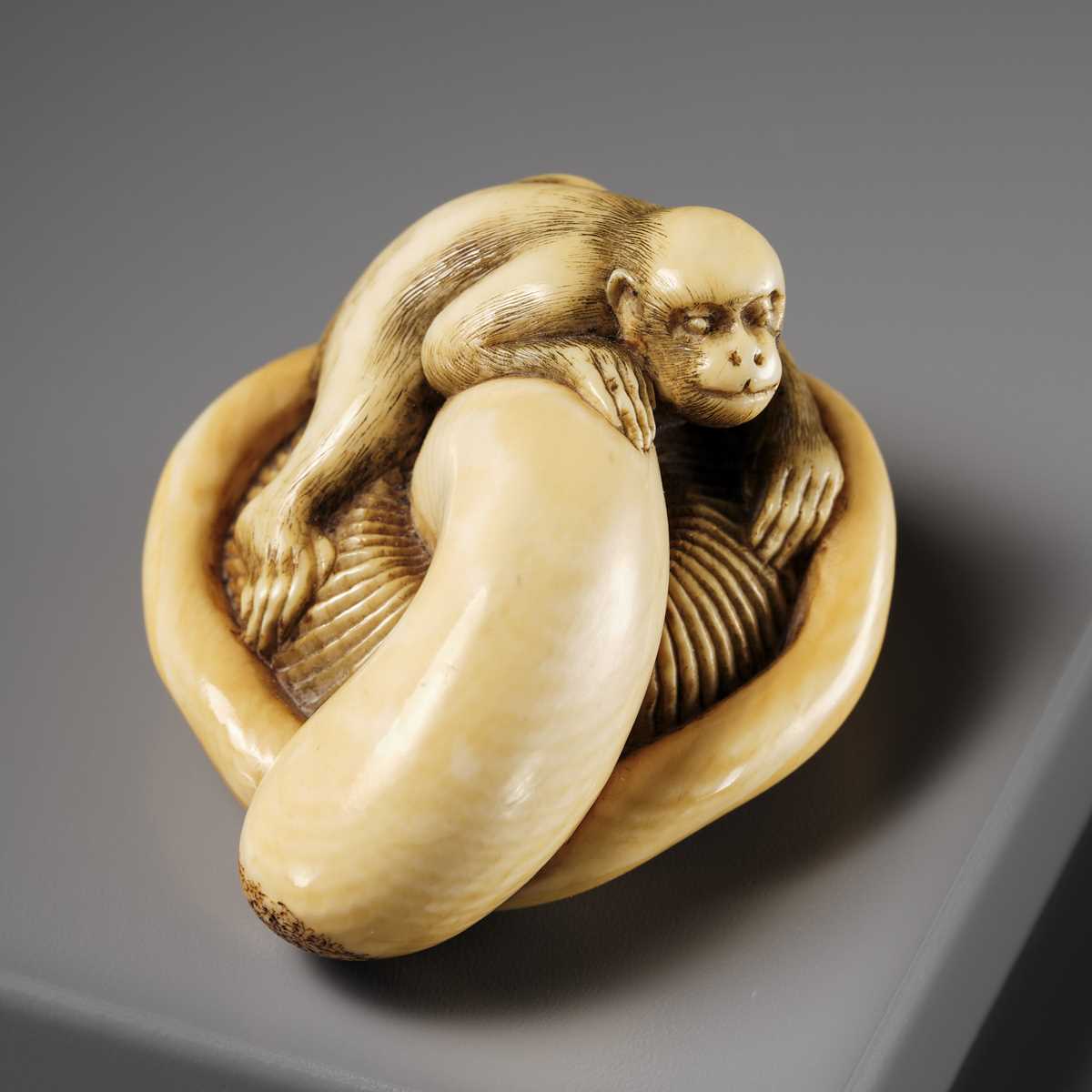 A SUPERB IVORY NETSUKE OF A MONKEY ON AN UPTURNED MUSHROOM, ATTRIBUTED TO OKATOMO